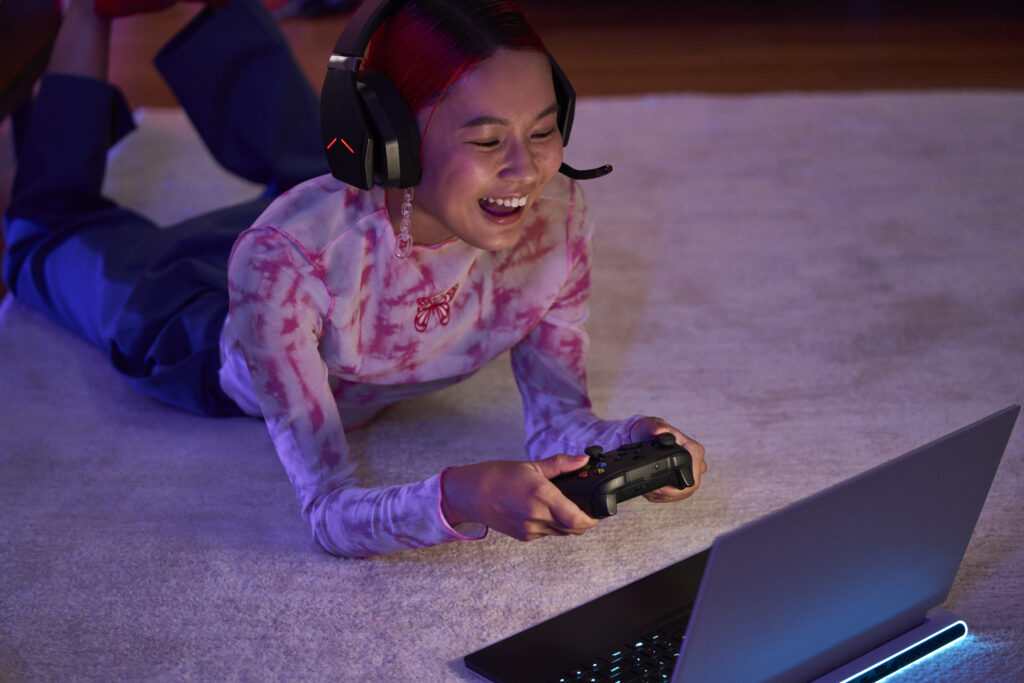 Teenager playing a game on a laptop