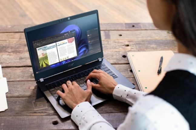 Decorative, over the shoulder view of a person typing on a laptop.