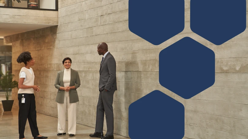 A man and two women standing in front of a wall