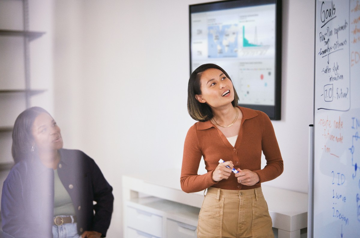 Developer engaged in a white board session collaborating with colleagues.