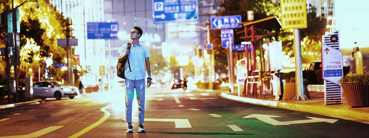 夜の通りの真ん中に立っている男